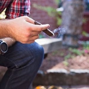 cigar being held by a man while lit